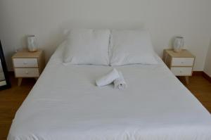 a white bed with a towel on it with two night stands at View Point Lake and Mountains in Annecy