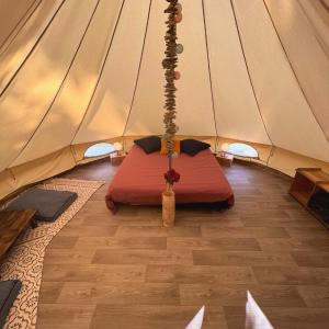 een kamer met een bed in een tent bij Le Tipi Glamour au bord de la rivière in Mios