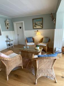 a living room with wicker chairs and a table at Klithjem Badehotel in Vejers Strand