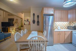 a kitchen with a table and a refrigerator at Muses Chalkida κατοικία με πισίνα in Kánithos