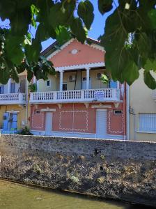 un edificio con puertas rojas y balcón en APPART AU GRAU D'AGDE VUE SUR LA MER ET L'HERAULT en Le Grau-dʼAgde