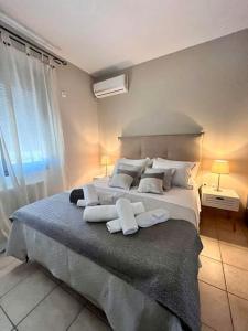 1 dormitorio con 1 cama grande con almohadas blancas en Muses Chalkida κατοικία με πισίνα en Kánithos