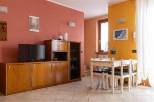 sala de estar con TV y mesa de comedor en IseoLakeRental - Appartamento Caterina, en Ranzanico