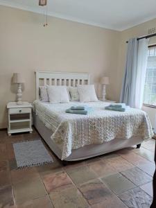 ein Schlafzimmer mit einem Bett mit einer weißen Tagesdecke in der Unterkunft Stone House in St Lucia