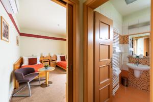 a room with a bed and a sink and a door at Jan Maria Hotel & Restaurant in Ostrava