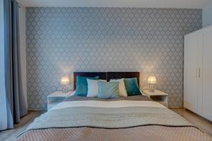 a bedroom with a bed with blue and white wallpaper at LM Apartamenty Mariacka Stare Miasto in Szczecin