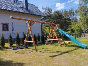 a playground with two swings and a slide at Domki Gorąca Bania in Gowidlino