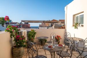 a patio with tables and chairs and flowers on a balcony at Santa Elena Boutique Rooms in Chania Town