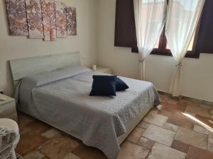 a bedroom with a bed with a blue pillow on it at Giolet's House in Villasimius