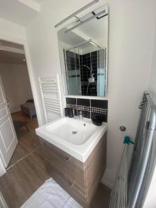a bathroom with a sink and a mirror at Il y a de l'amour dans l'air - studio lit king size in Arromanches-les-Bains