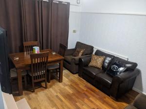 uma sala de estar com um sofá e uma mesa em Edgefield House em Barking