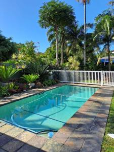 una piscina en un patio con palmeras en Stone House en St Lucia