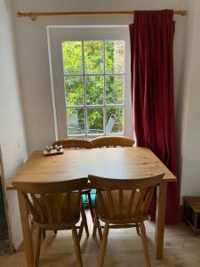 a wooden table and chairs in front of a window at Robinsons Cottage, central and quiet in Cockermouth