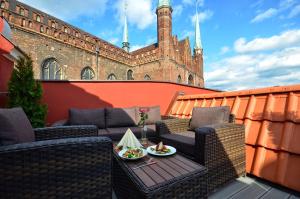 eine Terrasse mit 2 Stühlen und einem Tisch auf dem Balkon in der Unterkunft Stay inn Hotel Gdańsk in Danzig