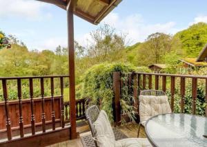 a patio with a table and chairs on a deck at Luxury Peak District lodge, hot tub, log burner, nr lake in Rudyard