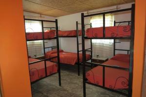 Treinta y TresにあるEl Caprichoの赤いシーツを使用した二段ベッド4組が備わる客室です。
