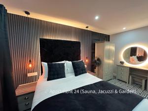 a bedroom with a large bed and a mirror at Serenity Apartments Bradford in Bradford