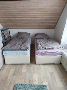 Habitación pequeña con 2 camas y techos de madera. en 2 Zimmer Monteur Wohnung DG, en Riedstadt