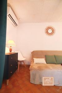 1 dormitorio con 1 cama y 1 mesa con lámpara en Le Zenith en Saint-Mandrier-sur-Mer