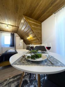 a dining room with a table and two glasses of wine at Gąsienicowy Widok in Poronin