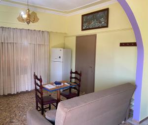 a living room with a table and a refrigerator at Anita's hosting in Kalamata