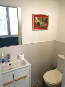 een badkamer met een toilet, een wastafel en een spiegel bij Alojamiento céntrico con encanto in Ferrol