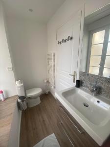 La vie est belle - centre d'Arromanches, terrasse في ارومانش لي بان: حمام أبيض مع حوض ومرحاض