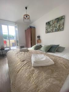 La vie est belle - centre d'Arromanches, terrasse في ارومانش لي بان: غرفة نوم عليها سرير وفوط
