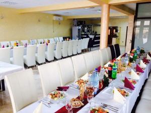 a long table with white chairs and plates of food at Casa Simona in Botiz