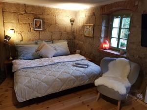 una camera da letto con un letto bianco e una sedia di ENJOY Cozy Romance Hills Forest Gardens Views Sauna Whirlpool Bath a Jablonné v Podještědí