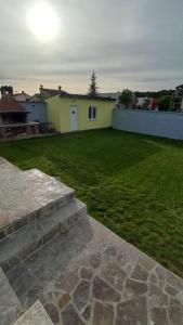 a backyard with a green lawn and a house at Caveromane 2 in Pula