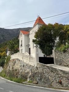 une maison blanche au-dessus d'un mur en pierre dans l'établissement L'Alba di Suffia Chb Double, à Venaco
