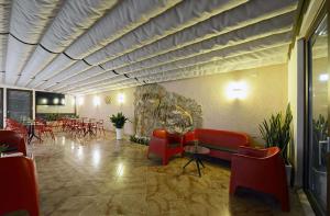 a restaurant with red chairs and tables in a room at Best Western Hotel Martello in Lampedusa