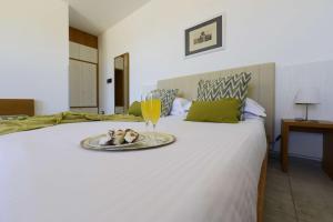 a bed with a tray of food and a glass of wine at Best Western Hotel Martello in Lampedusa