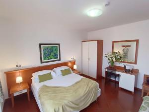a bedroom with a large white bed and two tables at Best Western Hotel Martello in Lampedusa
