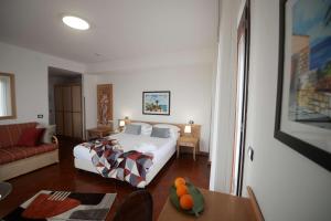 a bedroom with a bed and a couch and a table at Best Western Hotel Martello in Lampedusa