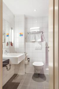 a white bathroom with a sink and a toilet at Mercure Northampton in Northampton