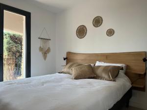 a bedroom with a large white bed with two pillows at La Cigalière à 5 minutes de la plage à pied in Le Lavandou