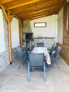 einen Tisch und Stühle auf einer Terrasse mit Kamin in der Unterkunft Къщи за гости Михайлови in Saparewa Banja