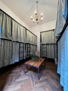 um quarto com cortinas, uma mesa e um lustre em Meridiano Hostel Boutique em Buenos Aires