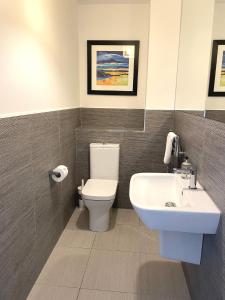 a bathroom with a white toilet and a sink at Millwood in Aviemore