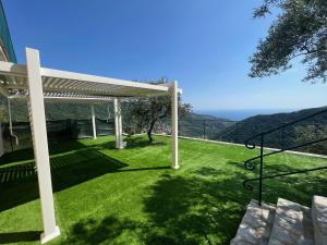 a view of a lawn with a pergola at Looky Hotel in Sori