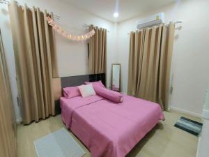 a bedroom with two beds with pink sheets and curtains at คานาโฮมฮัก หนองกุง in Ban Tao No