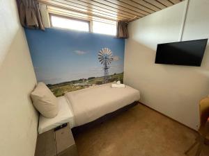 een kamer met een bed en een tv en een wiel bij Oer't Hout in Grou