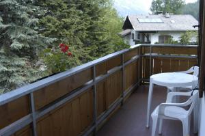 un balcón con una mesa blanca y sillas. en HAUS Lampacher, 