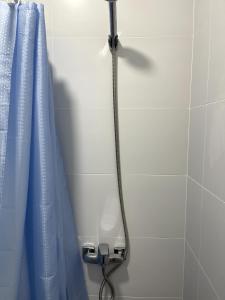 a shower with a blue shower curtain in a bathroom at PitStop Motel in Kamianske