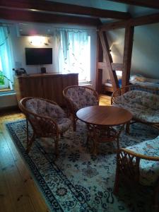 un soggiorno con sedie, tavolo e TV di Stajnia Swarzewo a Swarzewo
