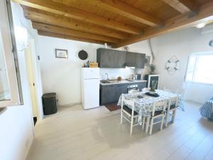 a kitchen with a table and a white refrigerator at Casa Lo Chef - ArgonautiVacanze in Portoferraio +29 photos