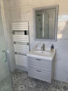 a white bathroom with a sink and a mirror at Pirou plage La Villa Mosca in Pirou