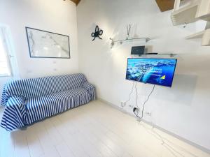 a living room with a couch and a flat screen tv at Casa Lo Chef - ArgonautiVacanze in Portoferraio